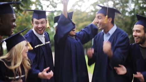 glückliche-Schüler-in-Mörtel-Boards-mit-Diplomen