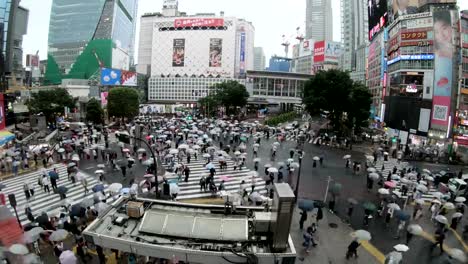 4K-Time-lapse-of-people-with-umbrellas-cross-the-famous-diagonal-intersection-in-Shibuya,-Tokyo,-Japan