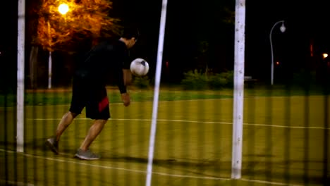 Joven-futbolista-patea-la-bola,-que-vuela-al-arquero,-que-coge-la-bola