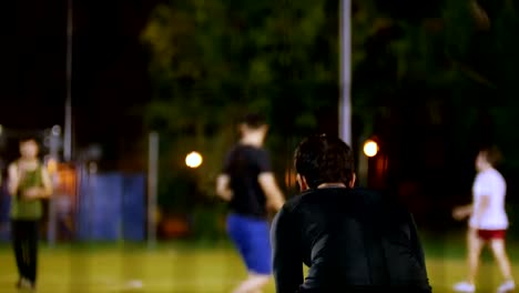 In-the-foreground,-the-goalkeeper-from-the-back,-who-plays-the-ball,-night-shooting