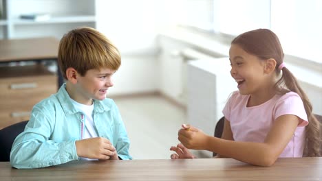 Der-junge-und-ein-Mädchen-Lachen-am-Tisch.-Slow-motion