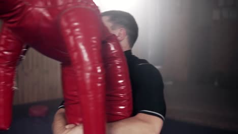 Fighter-hitting-dummy-punching-bag-in-gym-during-practicing-combat-technique