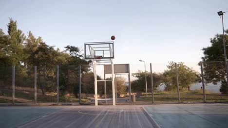 Escena-de-un-jugador-de-baloncesto-femenino-en-lanzar-la-bola-en-el-aro-en-el-local-al-aire-libre-cancha-de-baloncesto.-Material-Resumen