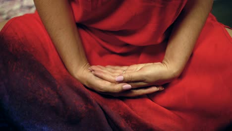 Meditation-female-in-red-robe-opens-her-eyes-for-sudden-look-in-camera-awakening