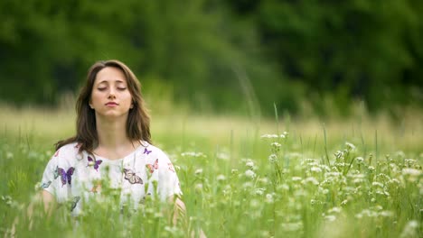 Junge-Frau-meditieren-im-hohen-grünen-Rasen,-Einssein-mit-der-Natur,-aufhören-zu-denken,