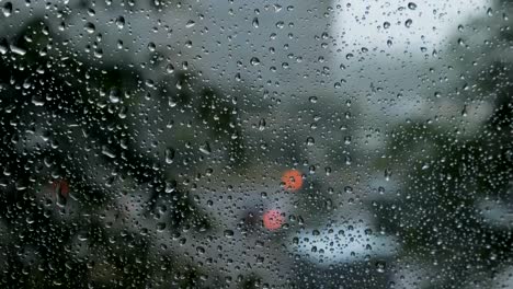 borrosa-la-vista-de-tráfico-a-través-de-un-parabrisas-de-coche-cubierto-de-la-lluvia-de-fondo