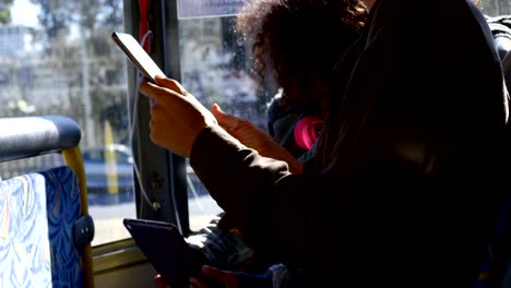 Mother-and-daughter-using-digital-tablet-while-travelling-in-bus-4k