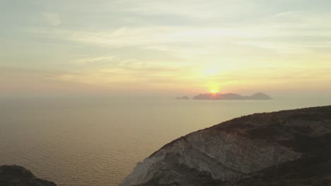 Schöne-junge-Frau-mit-Hut-in-der-Mode-bunt-Kleid-mit-Rock-und-Blick-auf-den-Sonnenuntergang-auf-Ponza-Inselberg-Italien-Blumen.-Luftaufnahme-der-Drohne.