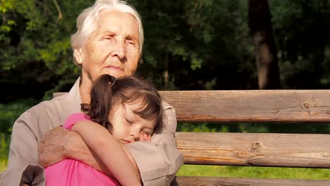 Das-Kind-schläft-auf-den-Händen-einer-älteren-Frau.