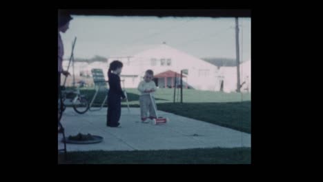 1960-mujer-con-niños-pequeños-en-el-patio-trasero