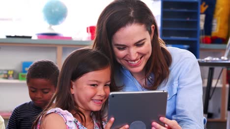 Lehrer-und-Mädchen-in-der-Grundschule-Klasse-mithilfe-der-Tablet-computer