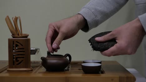 I-break-puer-tea-and-put-it-in-a-clay-teapot.-Chinese-tea-ceremony.