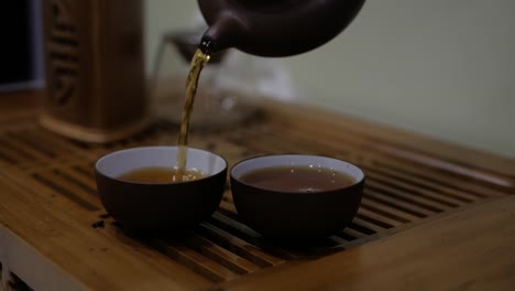 I-pour-tea-from-an-earthenware-teapot-into-bowls.-Chinese-tea-ceremony.