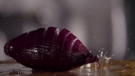 Falling-of-sliced-red-onion-into-the-wet-table.-Slow-motion-480-fps