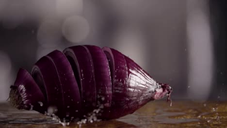 Falling-of-sliced-red-onion-into-the-wet-table.-Slow-motion-480-fps