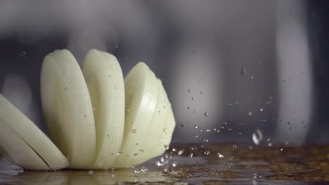 Falling-of-sliced-white-onion-into-the-wet-table.-Slow-motion-240-fps