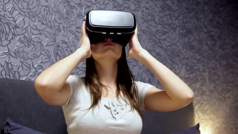 Schöne-junge-Frau-trägt-VR-Kopfhörer-im-Schlafzimmer.-Schaut-sich-um.-Video-wird-VR,-VR-Spiel-zu-spielen.