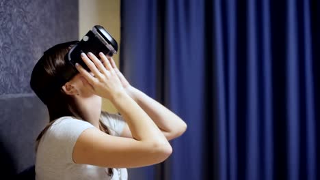 Schöne-junge-Frau-tragen-VR-Kopfhörer-im-Schlafzimmer-und-schaut-sich-um.-VR-Video-Nahaufnahme-ansehen.