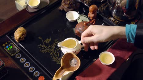 Chinese-traditions.-Master-pours-green-tea-into-a-white-cup