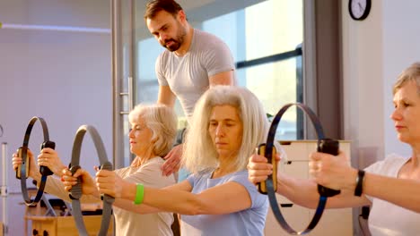 Entrenador-de-asistencia-a-senior-femenino-en-la-realización-de-yoga-4k