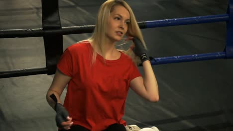 Beautiful-tired-blonde-sitting-in-the-ring-after-training