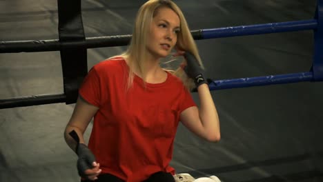 Hermosa-rubia-cansado-sentado-en-el-ring-después-del-entrenamiento