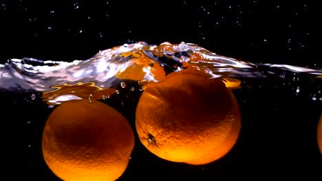 Oranges-fall-into-water-in-slow-motion