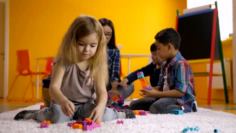 Preescolar-niña-jugando-con-bloques-de-juguete-colorido