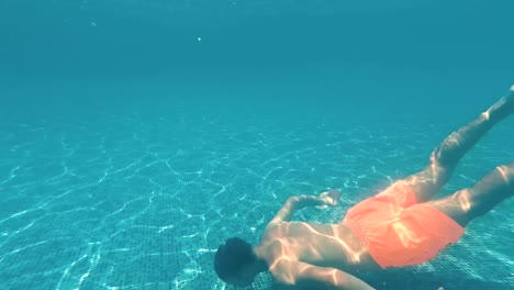 Young-guy-swims-underwater-in-a-swimming-pool