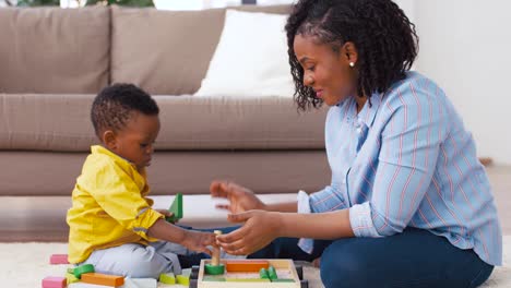 Mutter-und-Baby-spielen-mit-Spielzeugblöcken-zu-Hause