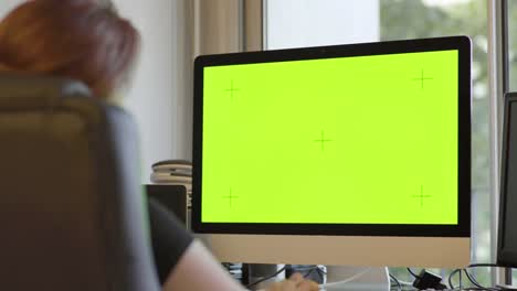 Frau-arbeitet-am-PC-mit-Mock-up-Green-Screen-in-ihrem-Studio.-Attraktive-und-wunderschöne-Frau-mit-roten-Haaren,-Internet,-Multi-Monitore,-Hacking,-freiberuflich,-Bewegungsdesigner,-Job.