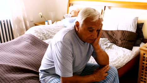 Gespannten-senior-Mann-sitzt-auf-dem-Bett-im-Schlafzimmer