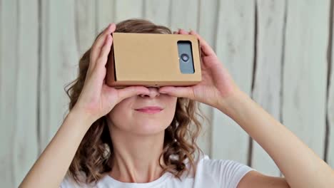 Young-curly-woman-using-Virtual-Reality-Glasses