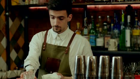 Barman-at-work-rubs-a-glass-loking-to-a-camera