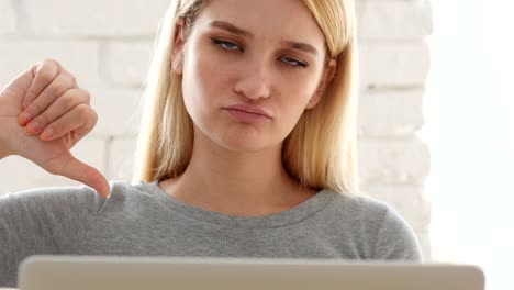 Thumbs-Down-by-Frustrated--Woman-Sitting-in-Office