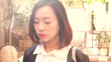 melancholic-pensive-young-Asian-woman-looks-at-the-camera-stady-cam