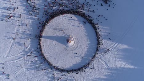 Circle-of-people-which-watch-burning-of-dummy-during-celebration-of-Russian-traditional-holiday-Maslenitsa.-Footage.-Aerial-view