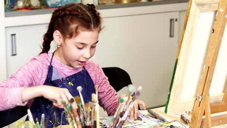 Little-happy-beautiful-girl-smiling-to-the-camera-at-the-art-studio