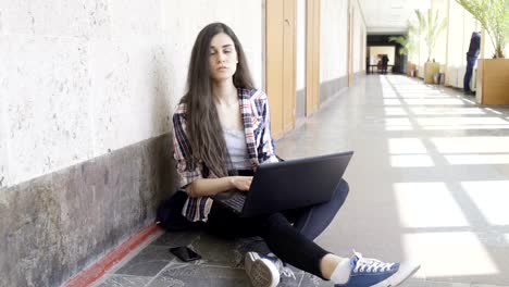 Mädchen-mit-Laptop-in-einem-College-Korridor