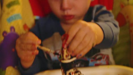 Video-von-einem-Jungen-Kleinkind-jungen-machen-ein-Weihnachten-Holzspielzeug-Soldat-Handwerk-mit-seiner-Mutter-an-ihrem-Wohnzimmertisch