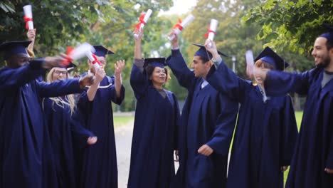 glückliche-Schüler-in-Mörtel-Boards-mit-Diplomen