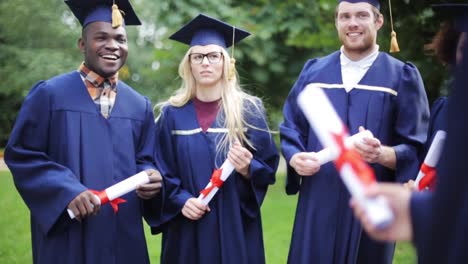 glückliche-Schüler-in-Mörtel-Boards-mit-Diplomen