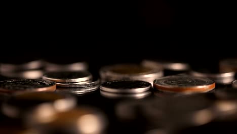 Close-up-slow-motion-Thai-Baht--money-coin-falling-to-the-floor-in-dark-light-,-business-and-financial-for-money-saving-or-investment-background-concept-with-black-copy-space-,-extremely-close-up-and-shallow-DOF