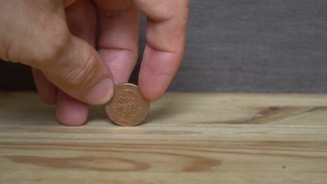 Business-concept---man-hand-collect-euro-coins-on-the-wooden-table.