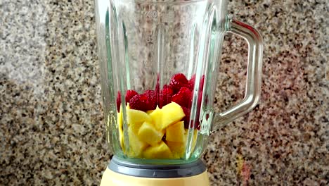 Füllung-in-den-Mixer-von-Äpfeln,-Himbeeren-und-Bananen.	Vorbereitung-der-Smoothie-in-den-Mixer-geben.