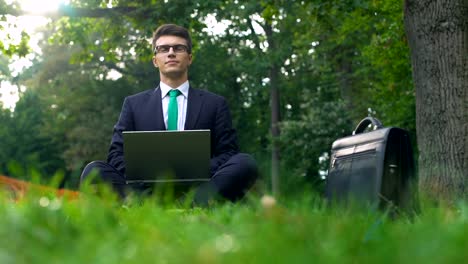 Young-manager-working-on-laptop-in-forest,-enjoying-nature,-escape-from-office