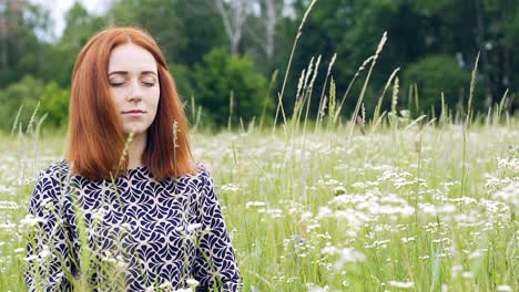 Meditating-woman-in-nature,-young-lady-sits-in-meditation-eyes-closed,-serenity