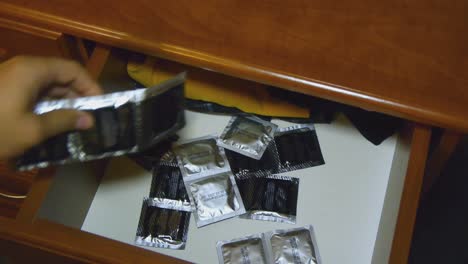 A-man-takes-a-condom-from-the-bedside-table.-Protection-against-aids-and-pregnancy.