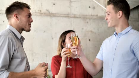 Successful-young-business-men-and-businesswoman-celebrating-with-champagne-in-office,-slow-motion.