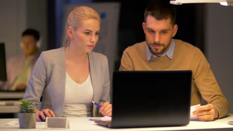 Business-Team-mit-Laptop-arbeiten-bei-Nacht